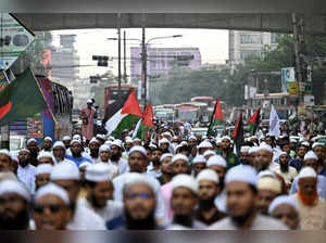 Protestors wave the national flags of Palestine and Bangladesh (L) as they shout slogans during an anti-Israel demonstration along a street in Dhaka on October 10, 2023.