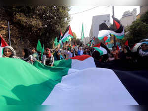 People carry a large Palestinian flag during a march to express solidarity with Palestinian people in the Gaza Strip, on October 13, 2023 in Beirut, as thousands of protesters poured onto the streets of several Middle East capitals in support of Palestinians amid Israeli air strikes on Gaza in reprisal for a surprise Hamas attack.