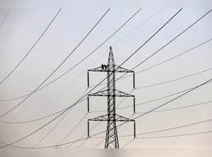 FILE PHOTO: Technicians work to clean power transmission tower in Karachi