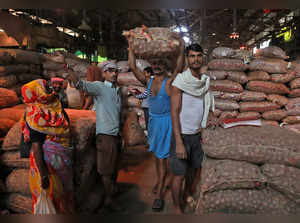 FILE PHOTO: Labourer carries sack of onions at wholesale market in Kolkata