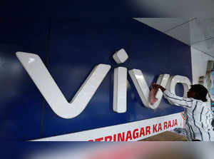 A man cleans the logo of a Chinese smartphone brand Vivo outside a store in Ahmedabad