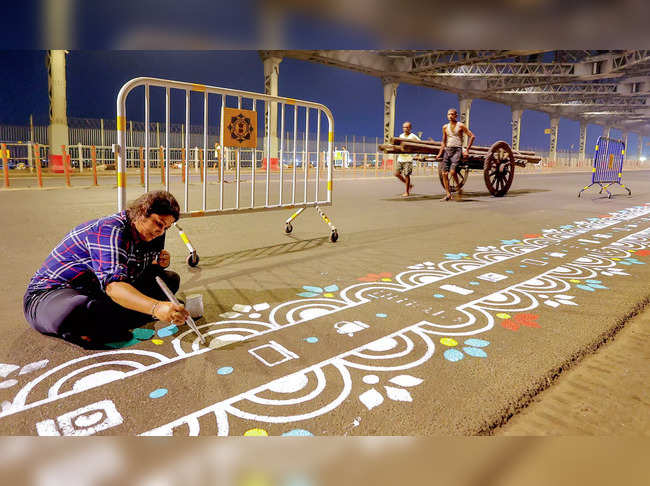 Kolkata: Art students prepare 'rangoli' on the Howrah bridge ahead of Durga Puja...
