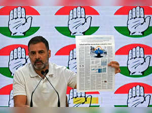 India's Congress party leader Rahul Gandhi speaks as he displays a foreign newspaper report on the alleged Adani Coal scam during a media briefing at the party headquarters in New Delhi on October 18, 2023.