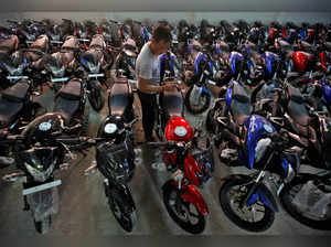 FILE PHOTO: FILE PHOTO: Worker cleans Bajaj motorcycle at a Bajaj showroom in Kolkata