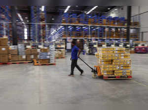 FILE PHOTO: A man drags a pallet loaded with boxes at the supply management company Prozo's distribution warehouse near Gurugram