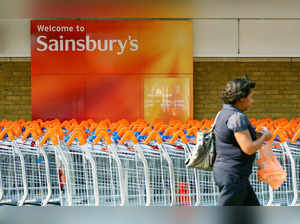 FILE PHOTO: A customer walks in front of a Sainsbury's store in south London