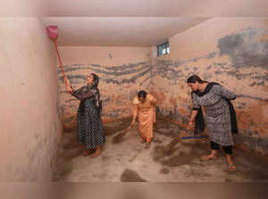 Arnia: Sarpanch Balbir Kaur with villagers clean a bunker after firing by the Pa...