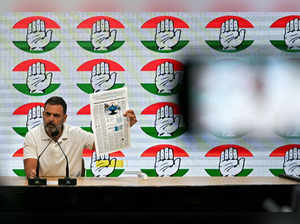 India's Congress party leader Rahul Gandhi speaks as he displays a foreign newspaper report on the alleged Adani Coal scam during a media briefing at the party headquarters in New Delhi on October 18, 2023.