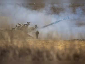 An Israeli army self-propelled howitzer fires rounds towards the Gaza Strip in southern Israel on October 13, 2023.