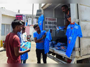 A vendor (C) sells Indian cricket jerseys to customers outside the Narendra Modi Stadium in Ahmedabad on October 10, 2023.