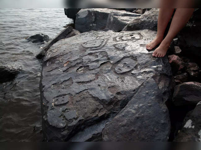 Ancient carvings on Amazon river rock exposed by falling water level during drought in Manaus