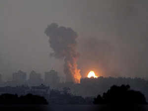 Fire and smoke rise following an Israeli airstrike in the Gaza Strip, as seen fr...