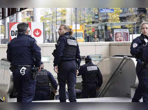 French police officers stand at the entrance of a metro station after a woman making threats on an RER train was shot and wounded by police, in Paris on October 31, 2023.