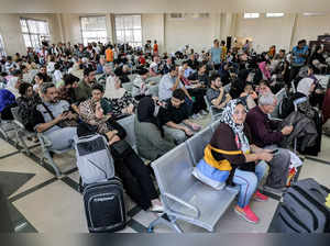 People sit in the waiting area at the Rafah border crossing in the southern Gaza Strip before crossing into Egypt on November 1, 2023.