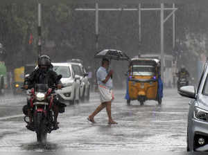 Thiruvananthapuram: Commuters on a road amid rainfall, in Thiruvananthapuram. Cy...