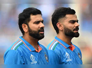 India's captain Rohit Sharma (L) and Virat Kohli stand for their national anthem before the start of the 2023 ICC Men's Cricket World Cup one-day international (ODI) match between India and South Africa at the Eden Gardens in Kolkata on November 5, 2023.