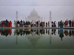 Agra: Tourists visit the Taj Mahal amid dense smog, in Agra. (PTI Photo)...