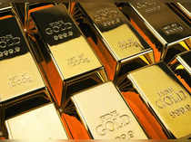 Gold edges lower as dollar firms, Fed speakers in focus