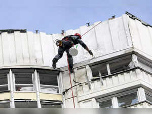 A worker repairs a damage on a building in Moscow, Russia after a Ukrainian dron...