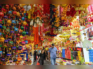 Shoppers walk under decorative ornaments displayed for sale in a market at Little India district in Singapore on October 23, 2023, ahead of Hindu festive celebration of Diwali, locally known as Deepavali.