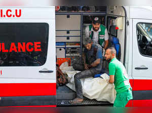 Medics transport injured Palestinians into Al-Shifa hospital in Gaza City following Israeli bombardment on October 15, 2023.