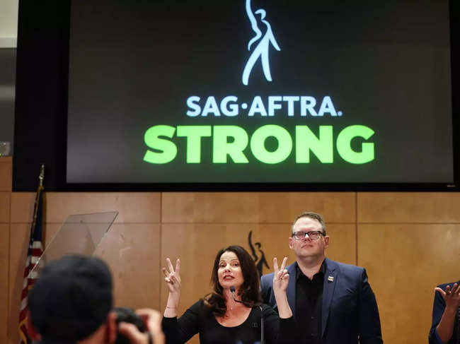 SAG-AFTRA President Fran Drescher (L) speaks as SAG-AFTRA National Executive Director Duncan Crabtree-Ireland looks on at a press conference discussing their strike-ending deal with the Hollywood studios.