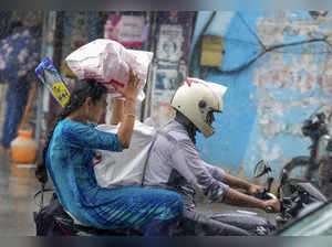Chennai: Commuters caught in rain, in Chennai. (PTI Photo/R Senthil Kumar)...