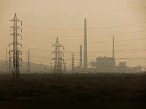 Power grids are seen next to a chemical factory on a smoggy morning in Mumbai