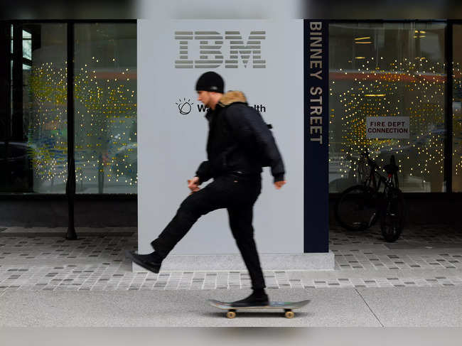 A skateboarder passes the sign for an IBM office in Cambridge