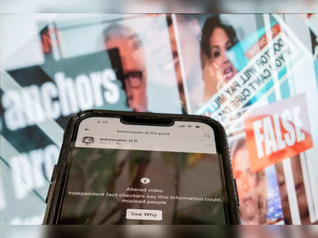 This photo illustration created in Washington, DC, on November 17, 2023, shows a phone screen showing a social media video marked as an "altered video," in front of a fact-checked image of news anchors where the claim about them was found to be false.