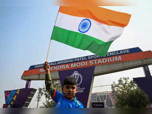 A boy waves the national flag of India outside the Narendra Modi Stadium in Ahmedabad on November 18, 2023, on the eve of the 2023 ICC Men's Cricket World Cup one-day international (ODI) final match between India and Australia.