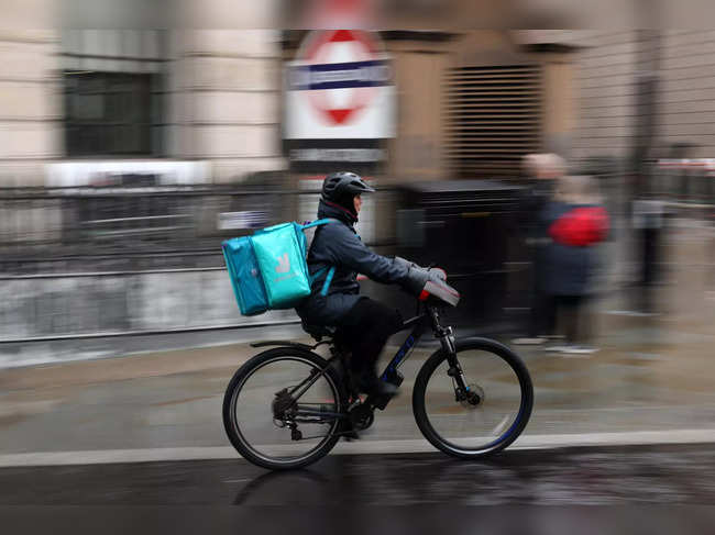 A Deliveroo rider rides their electric bike in the City of London on November 10, 2023.