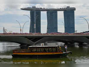 People ride on a tour boat towards the Singapore River past Marina Bay Sands in Singapore on November 17, 2023.