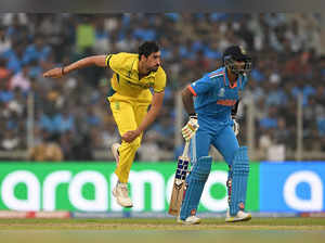 Australia's Mitchell Starc (L) bowls next to India's Suryakumar Yadav during the 2023 ICC Men's Cricket World Cup one-day international (ODI) final match between India and Australia at the Narendra Modi Stadium in Ahmedabad on November 19, 2023.