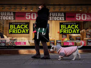 A woman walks past a shop displaying Black Friday sales signs in Bilbao