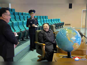 This picture taken on November 24, 2023 and released from North Korea's official Korean Central News Agency (KCNA) on November 25, 2023 shows North Korea's leader Kim Jong Un (R) preparing for the operation of the reconnaissance satellite during a visit to the Pyongyang General Control Center at the State Directorate of Aerospace Technology in Pyongyang.