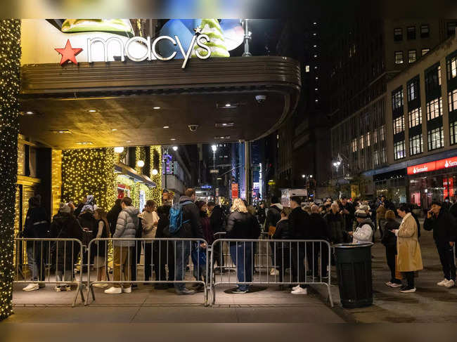 People wait in line outside Macy's before opening on "Black Friday" in New York City on November 24, 2023.