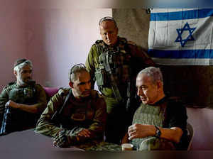 In this handout picture taken and released by the Israeli Prime Minister's Office on November 26, 2023 Israeli Prime Minister Benjamin Netanyahu (R) meets soldiers at an undisclosed location in the Gaza Strip.