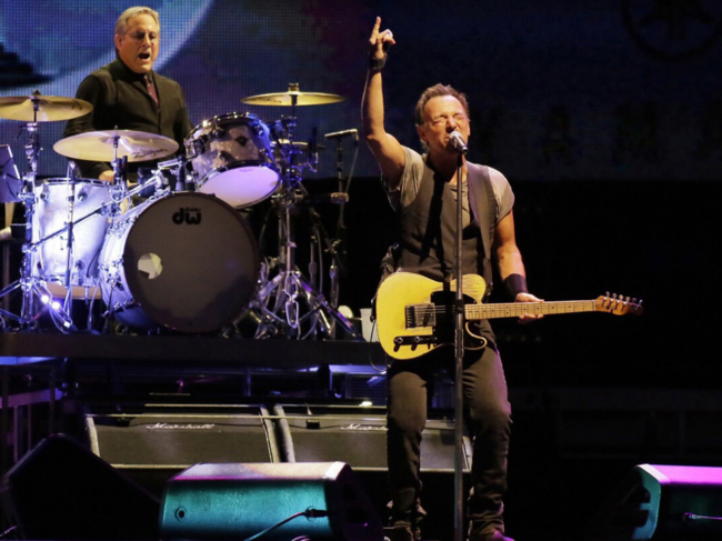 Max Weinberg plays the drums (Left) while Bruce Springsteen and the E Street Band perform.