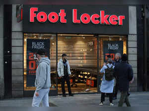People walk past the damaged entrance to a Foot Locker shop of a in Dublin on November 24, 2023, following a night of protests.