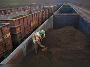A worker levels the iron ore in a freight train at a railway station at Chitradurga in Karnataka