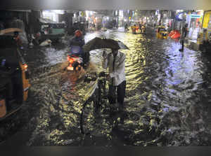 Chennai: Commuters make their way amid rain, in Chennai. (PTI Photo)(...
