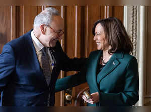 US Senate Majority Leader Chuck Schumer presents US Vice President Kamala Harris with a "golden gavel" after she cast her 32nd tie-breaking vote in the Senate, the most ever cast by a Vice President, at the US Capitol in Washington, DC, December 5, 2023.