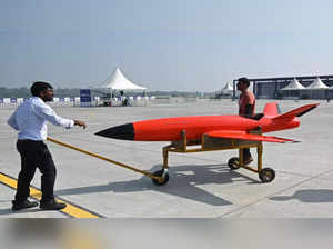 Exhibitors haul an unmanned aerial vehicle (UAV) for display during the Bharat Drone Shakti 2023 exhibition at the Hindon Airbase station in Ghaziabad on September 25, 2023