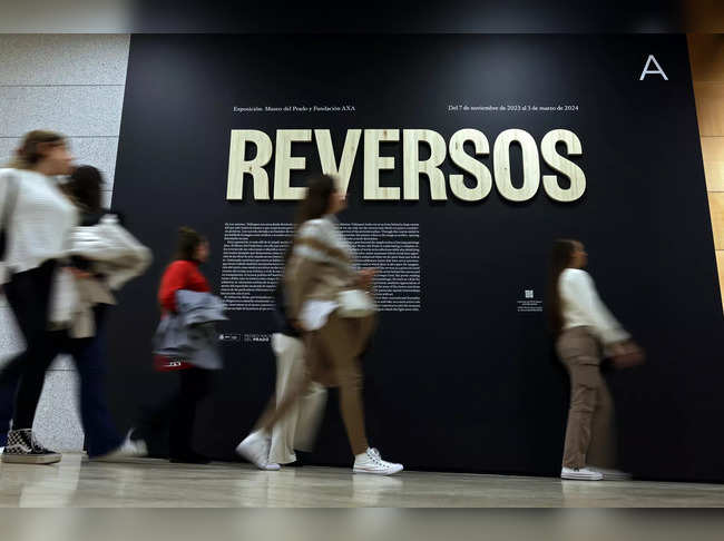 Visitors walk past the entrance of the Reversos exhibition, which presents the hidden back sides of renowned paintings, at the Prado Museum in Madrid on December 5, 2023.