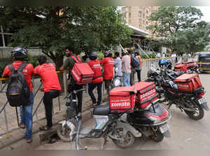 Gig workers wait in line to collect their delivery order outside a mall in Mumbai,