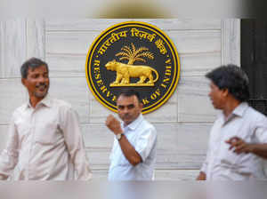 Mumbai: People walk past an emblem of the Reserve Bank of India (RBI) at the RBI...