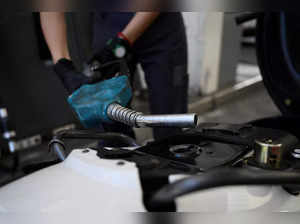 A pump attendant pumps fuel into a motorcycle at a gas station in Buenos Aires on December 12, 2023.