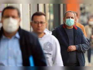Iranian men wear face masks as they walk in Tehran on December 6, 2023 amid severe air pollution.