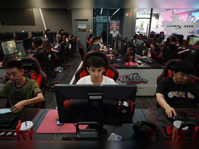 People play computer games at an internet cafe in Beijing on September 10, 2021, days after Chinese officials summoned gaming enterprises including Tencent and NetEase, the two market leaders in China's multi-billion-dollar gaming scene, to discuss further curbs on the industry.